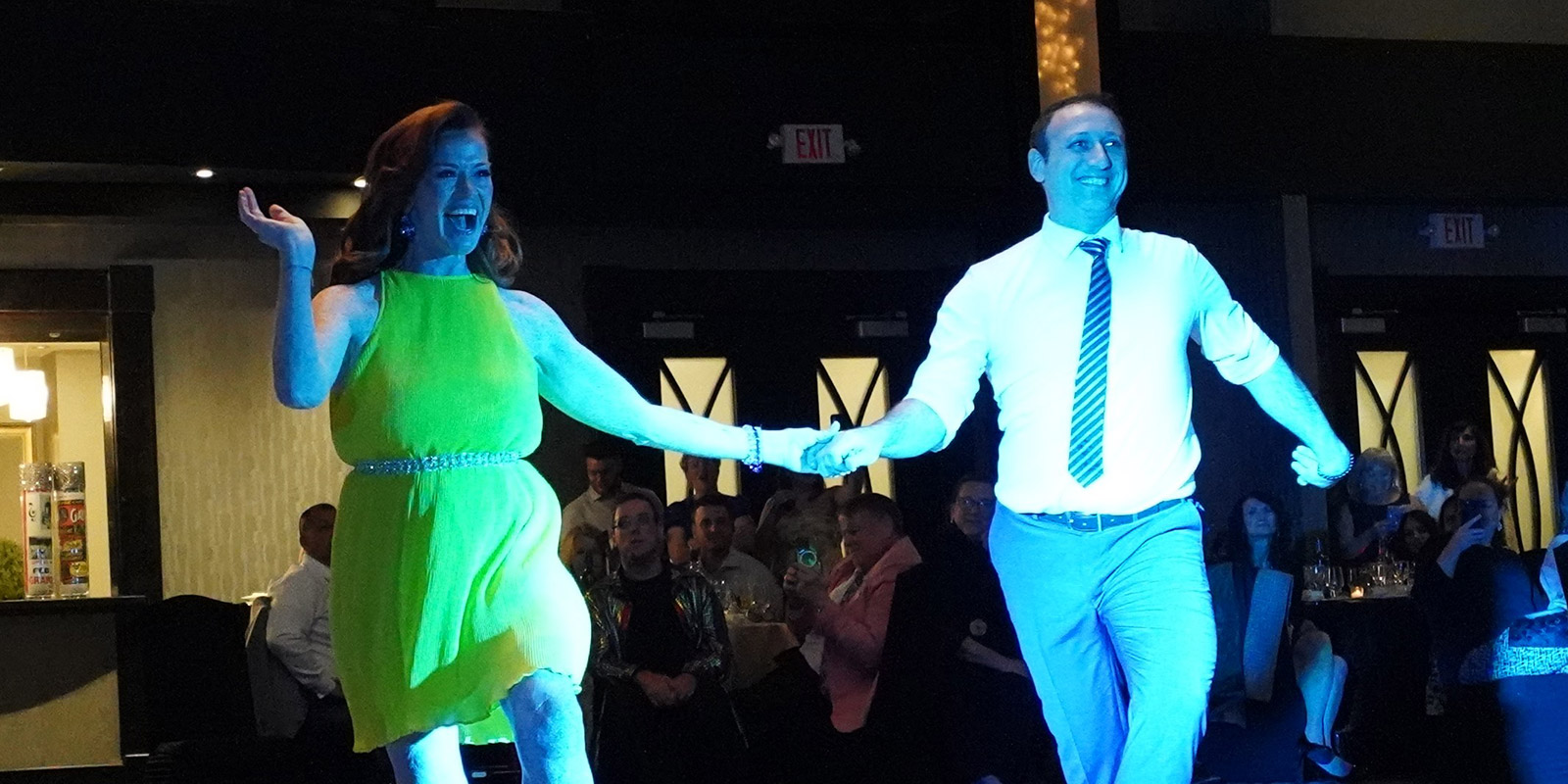 A couple dance in matching gold outfits.